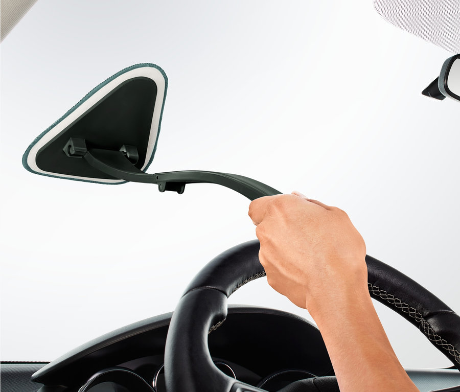 El, araba ön camının iç kısmında araba ön cam temizleyicisini kullanıyor.