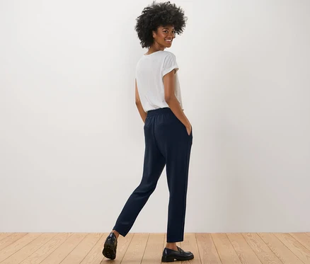 Kadın lacivert Joggpants ve beyaz tişörtle poz veriyor.
