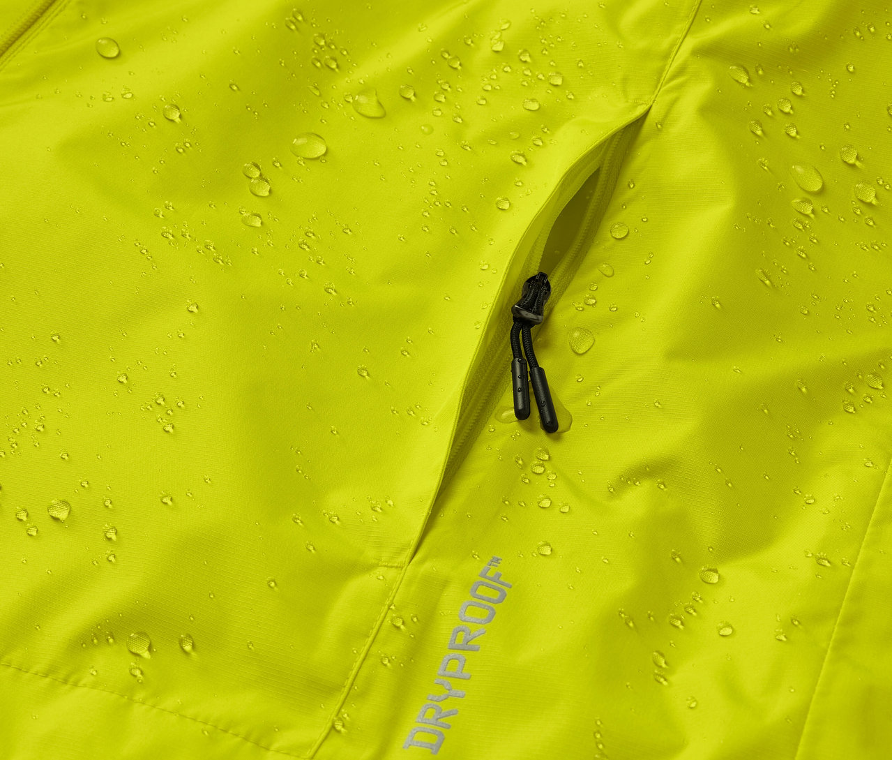 Su damlaları ve cepli sarı bir yağmurluğun yakın çekimi.