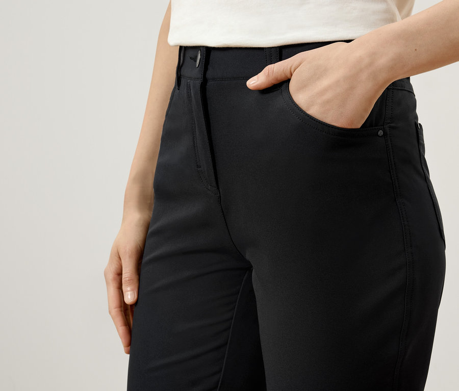 Kadın siyah pantolonun cebinde elini tutuyor.