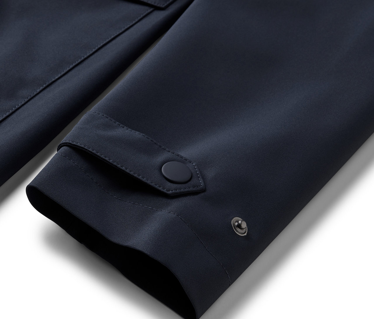 Mavi renkli bir yağmurluk trençkotun kol detayının yakın çekimi.