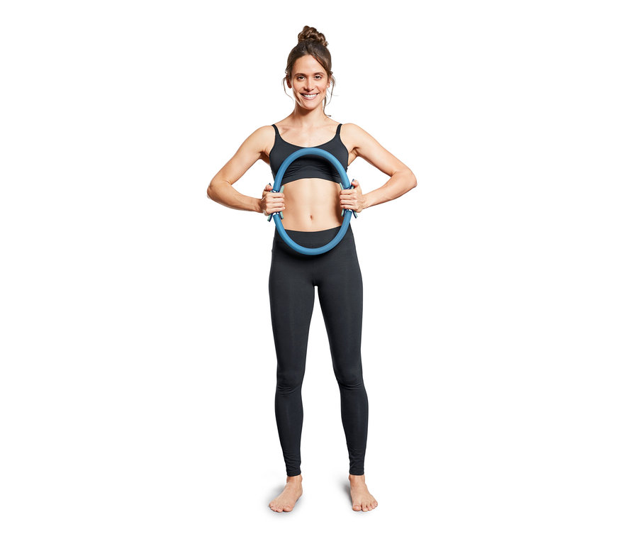 Kadın mavi pilates halkası tutuyor.