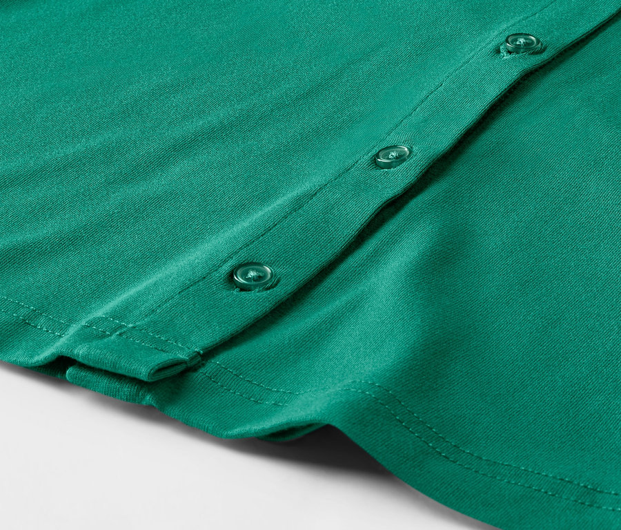 Zümrüt yeşili, düğmeli bir bluzun yakın çekimi.