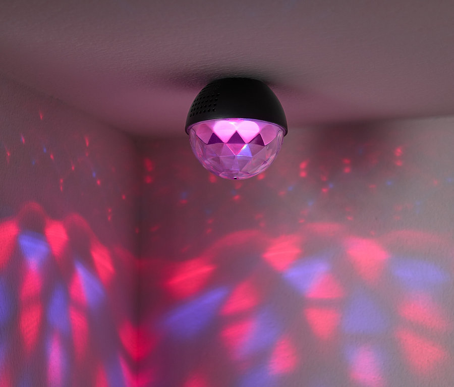 Tavana monte edilmiş, odanın duvarlarına kırmızı ve mavi ışıklar yansıtan bir disko topu var.
