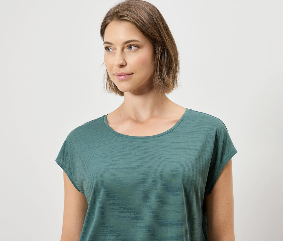 Kadın yeşil bir tişört giyiyor.