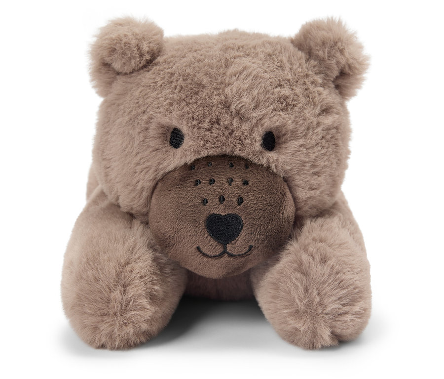 Kahverengi oyuncak ayı karnının üzerinde yatıyor.