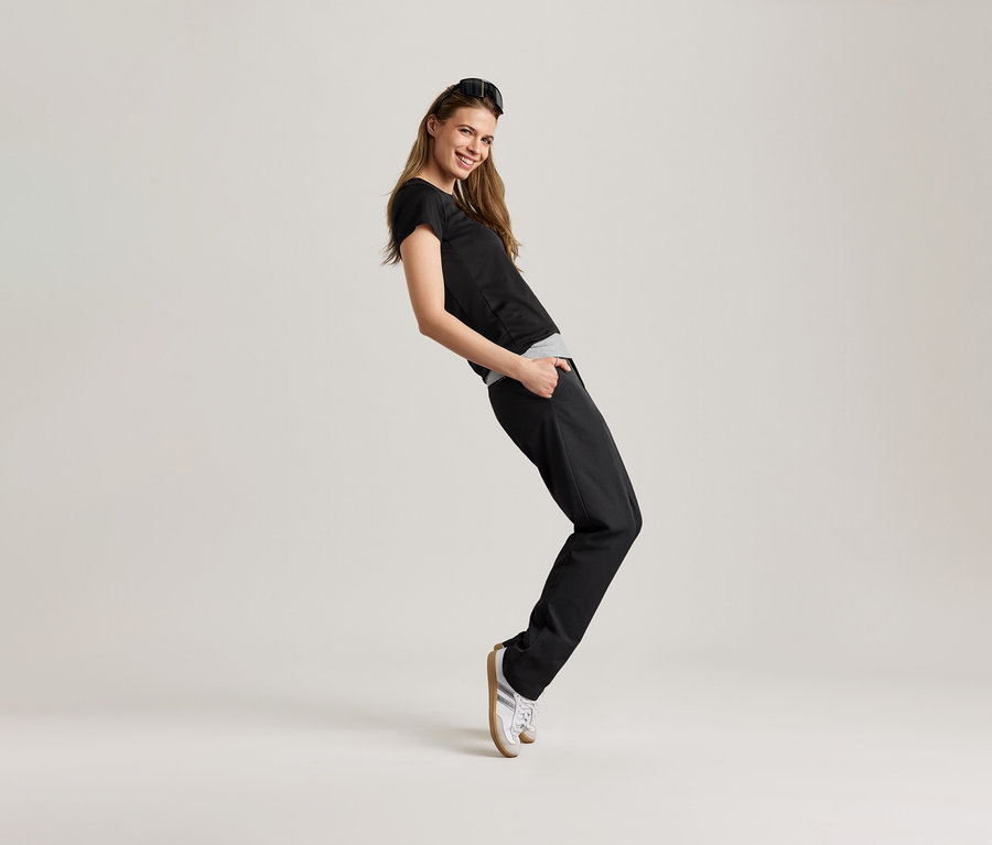 Kadın siyah spor tişörtü ile poz veriyor.