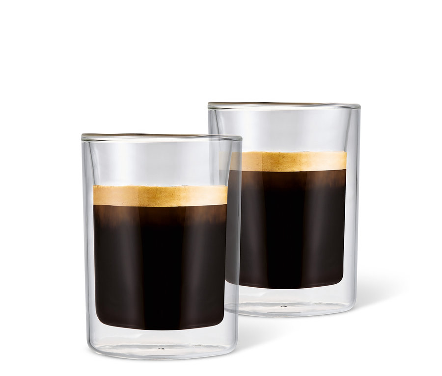 Beyaz bir arka plan üzerinde köpüklü kahve ile doldurulmuş iki adet Caffè Crema Bardağı.