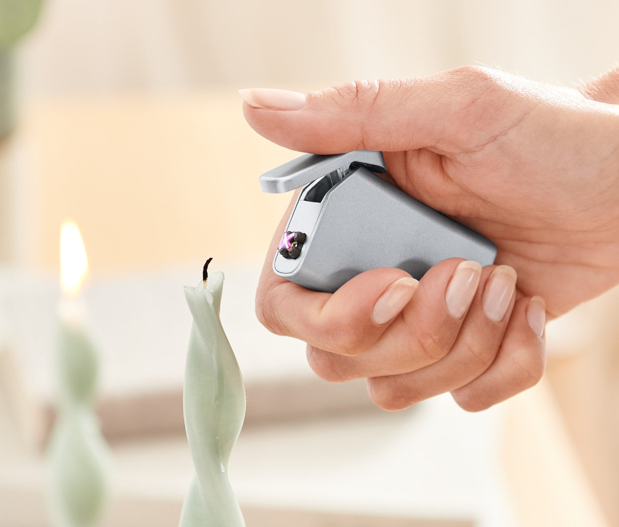 Bir kadın elektrikli çakmak ile bir mum yakıyor.