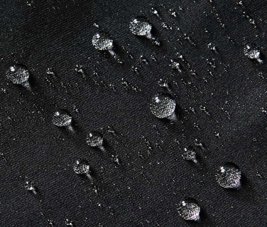 Yüzeyinde su damlaları olan siyah su itici spor taytın yakın çekimi.