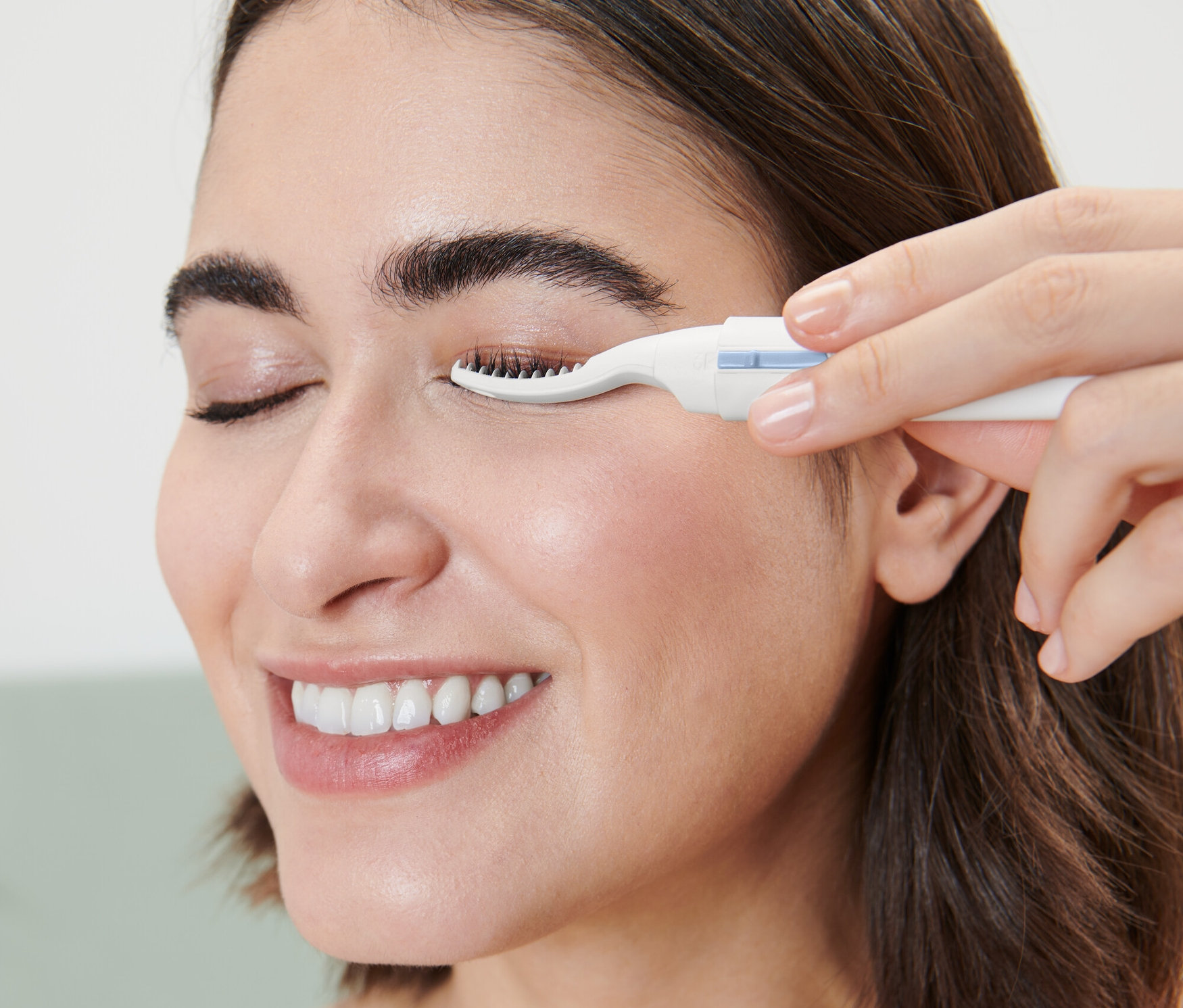 Kadın ısıtmalı kirpik kıvırıcı kullanıyor