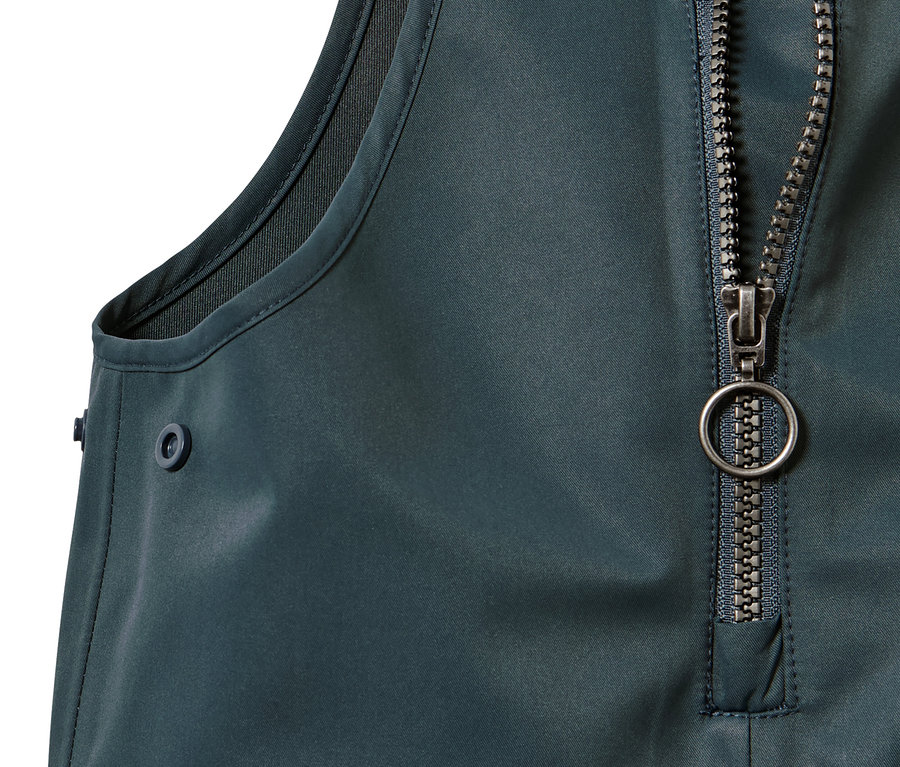 Fermuarı ve düğmesi olan küçük çocuk yağmur pantolonu detayı.