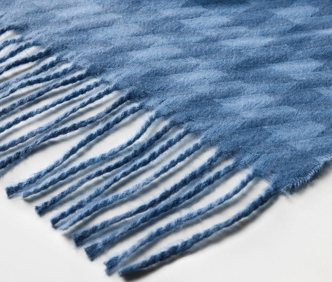 Püsküllü mavi bir şalın detayı.