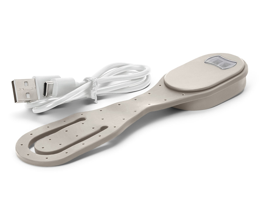 Beyaz bir arka plan üzerinde bej renkli, ışıklı bir kitap klipsi ve buna bağlı USB şarj kablosu bulunmaktadır.