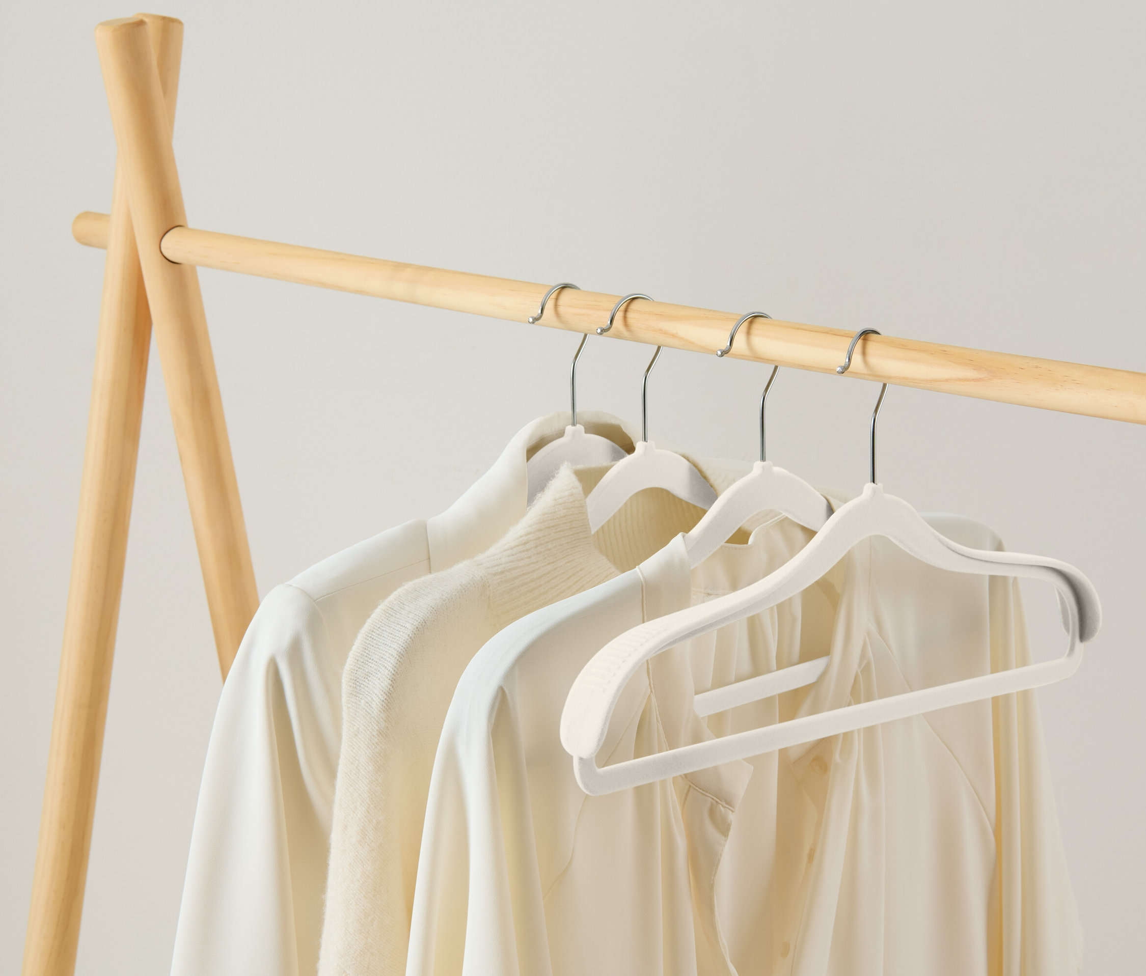 Ahşap bir askılıkta beyaz askılarda asılı duran üç beyaz bluz bulunmaktadır.