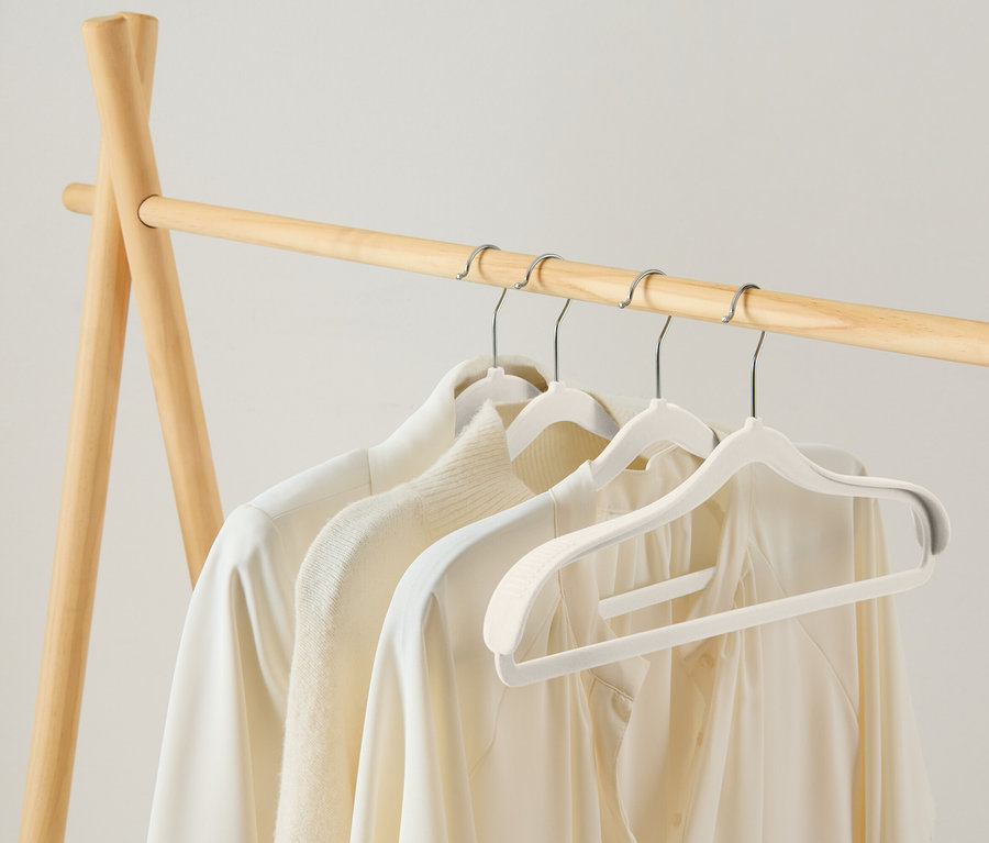 Ahşap bir askılıkta beyaz askılarda asılı duran üç beyaz bluz bulunmaktadır.