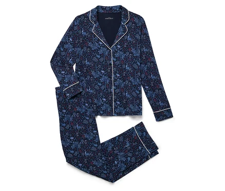 Desenli lacivert bir pijama takımı beyaz bir zeminde katlanmış halde duruyor.