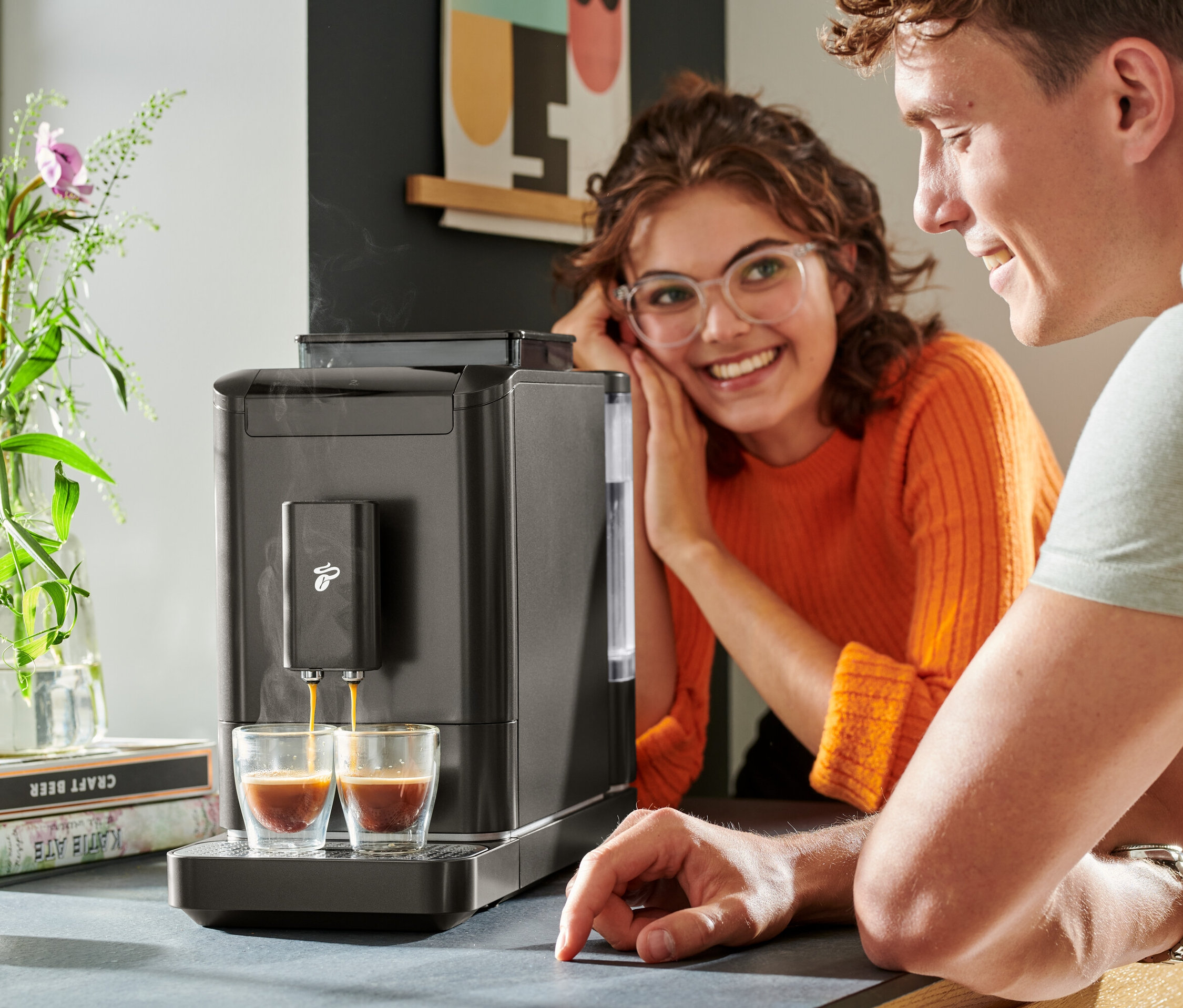 İki kişi, »Esperto2 Caffè« Tam Otomatik Kahve Makinesinden iki bardağa kahve dolmasını izliyor.