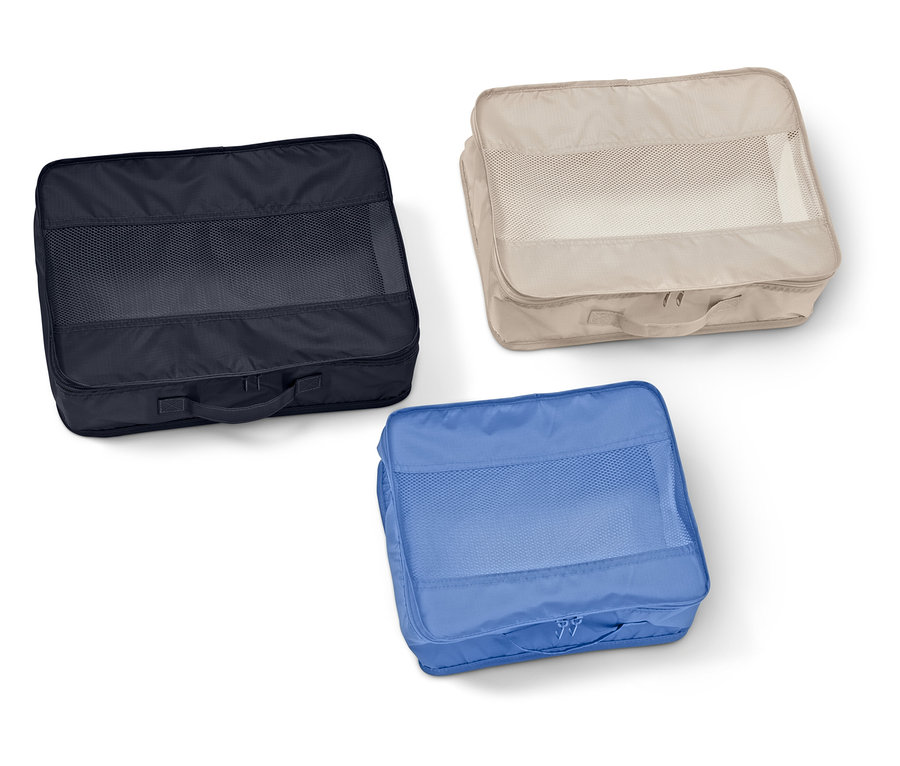 Lacivert, bej ve mavi renklerde, file pencereli üç adet dikdörtgen bavul düzenleyici beyaz bir zemin üzerinde duruyor.