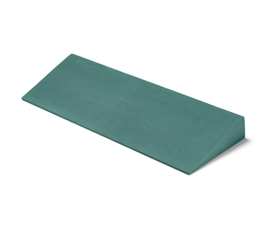 Beyaz bir arka plan üzerinde duran yeşil bir Üçgen Yoga Bloğu.