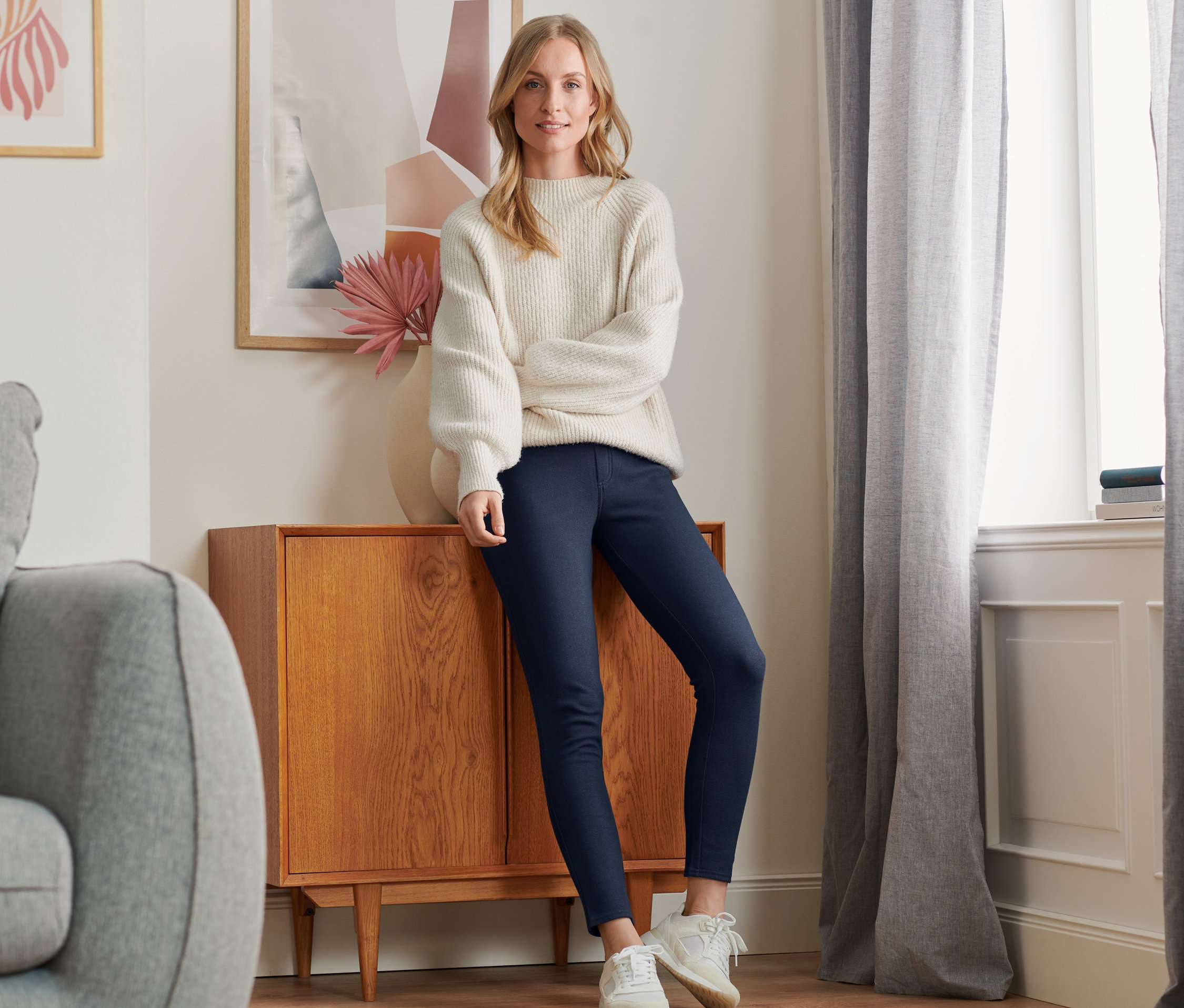 Komodine yaslanan bir kadın, Jean Görünümlü Şardonlu Tayt, Koyu Mavi Denim giyiyor.