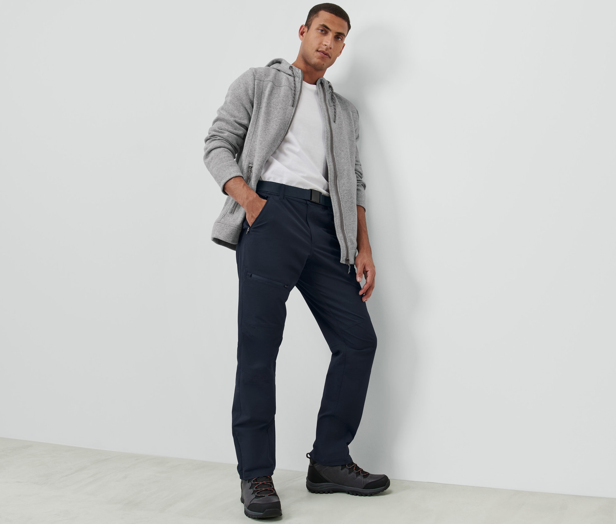 Lacivert outdoor pantolonu giyen bir adam poz veriyor.