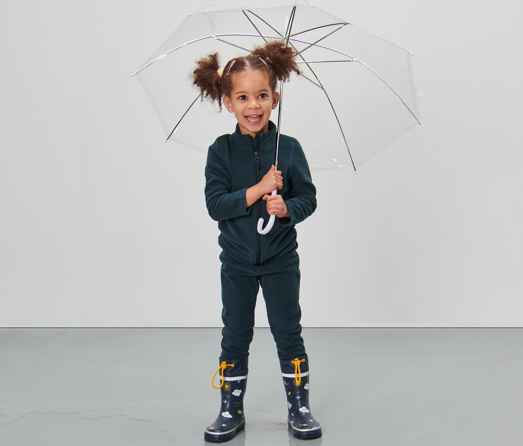 Şeffaf şemsiye tutan, Küçük Çocuk Polar Takım, 2 Parça giyen ve lastik çizme giyen kız çocuğu.