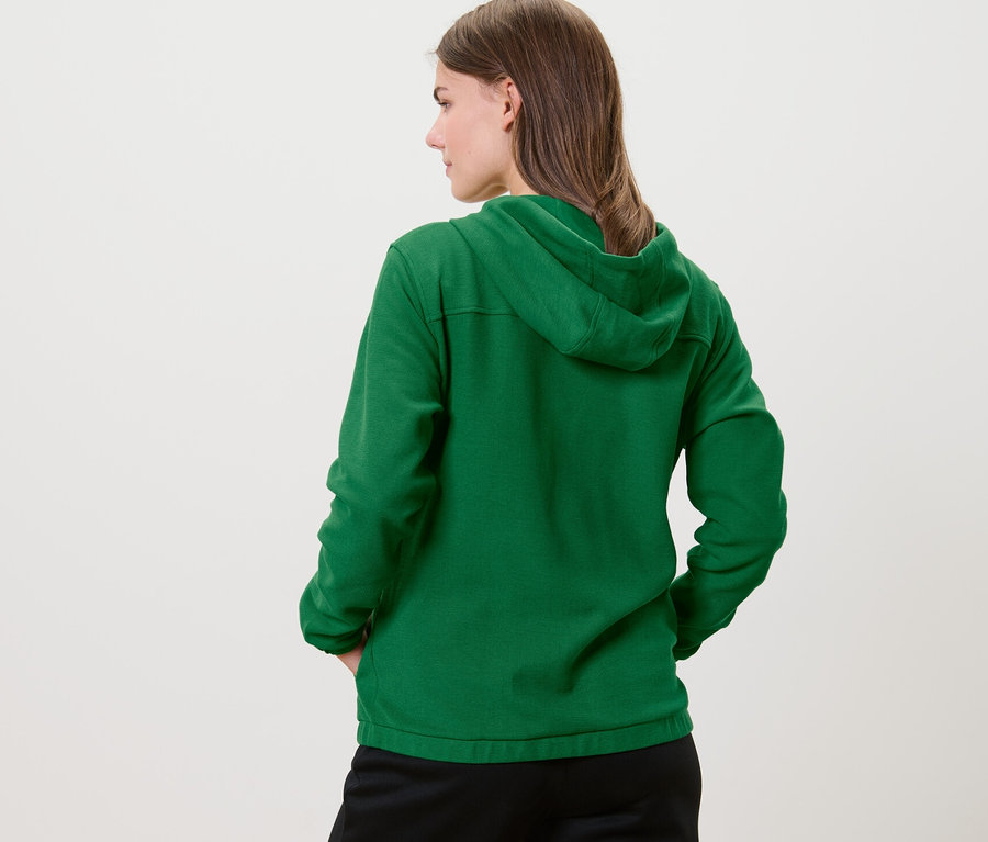 Arkası dönük bir kadın yeşil Sweat Mont giyiyor.