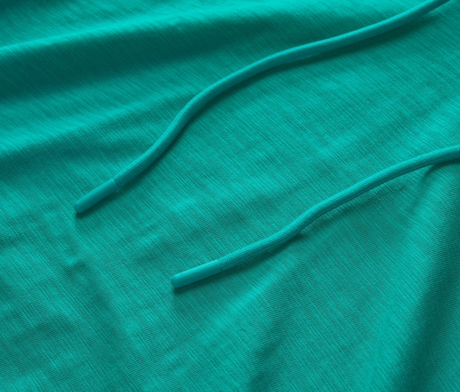 İpli, turkuaz renkli bir jarse kapüşonlu sweatshirt'ün yakın çekimi.