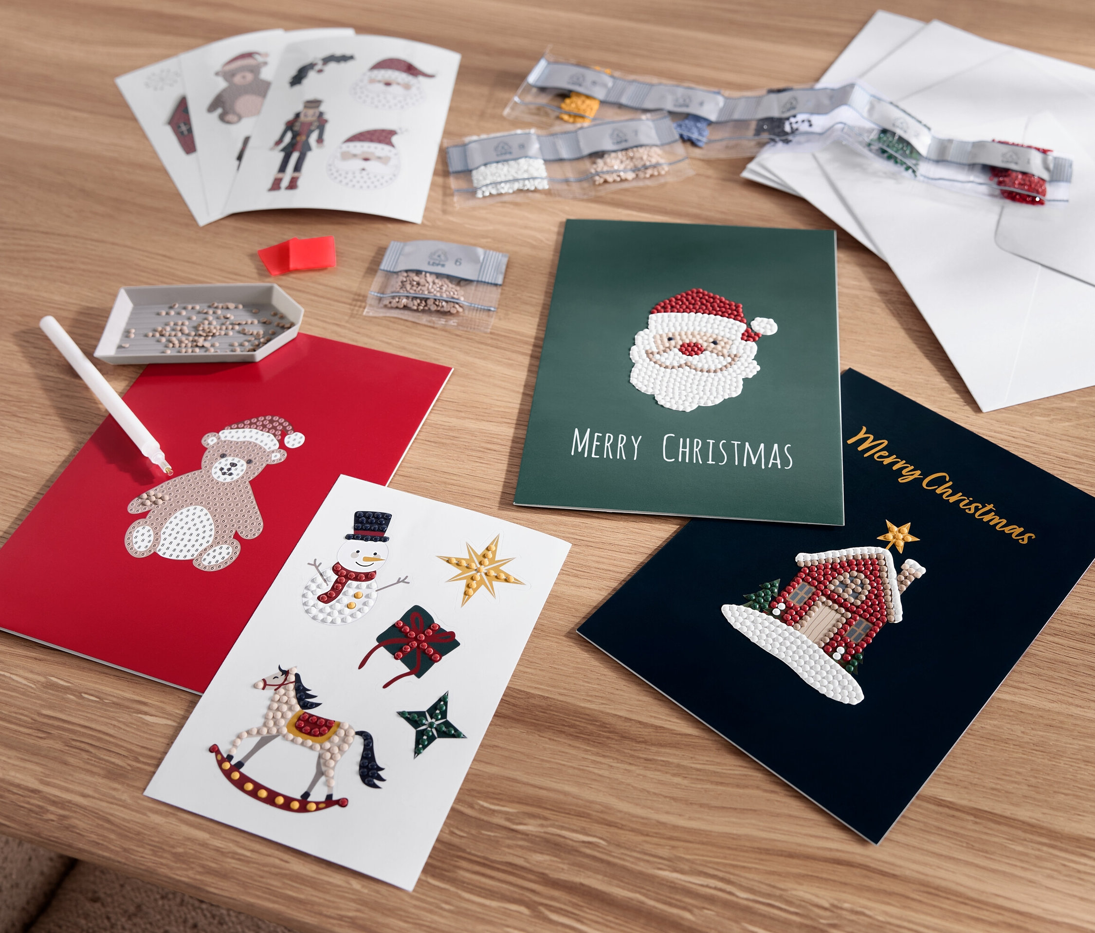 Ayı, Noel Baba, kardan adam ve ev motifleriyle serilmiş Noel tebrik kartları.