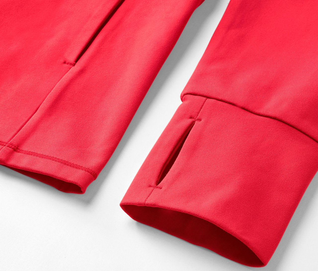Parmak deliği ve cebi olan kırmızı bir sweatshirt'ün yakın çekimi.