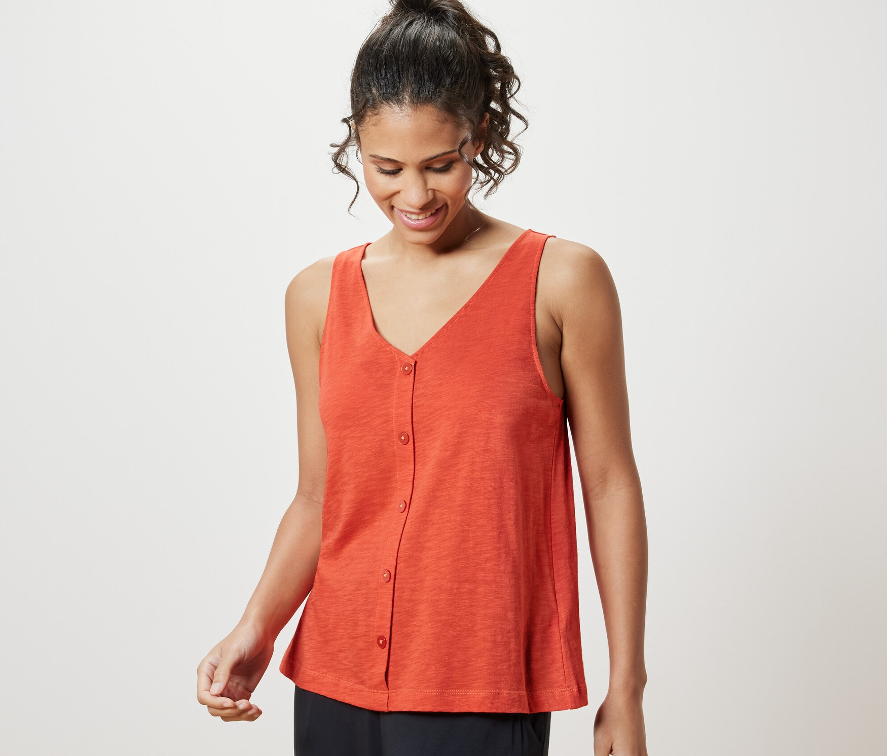 Kadın turuncu modal karışımlı bir üst giyiyor.