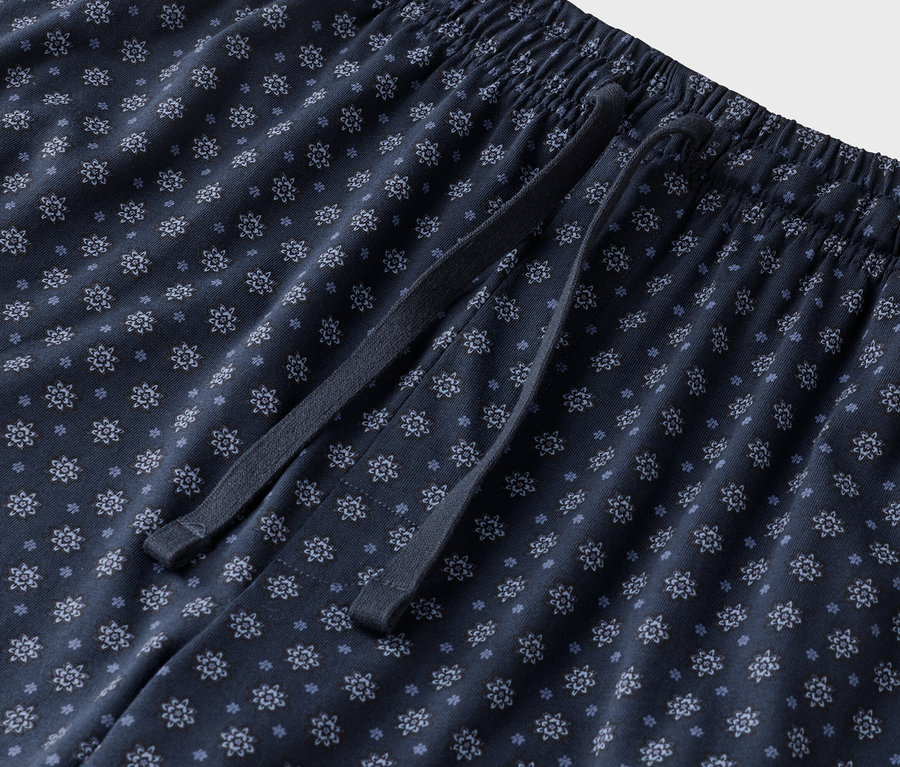 Çiçek desenli ve bağcıklı lacivert bir pijama altının yakın çekimi.