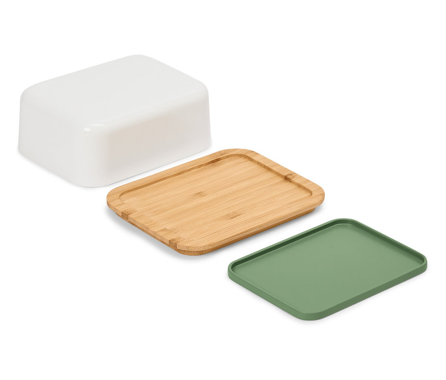 Beyaz bir arka planda beyaz bir kap, tahta bir tepsi ve yeşil bir tepsi bulunmaktadır.