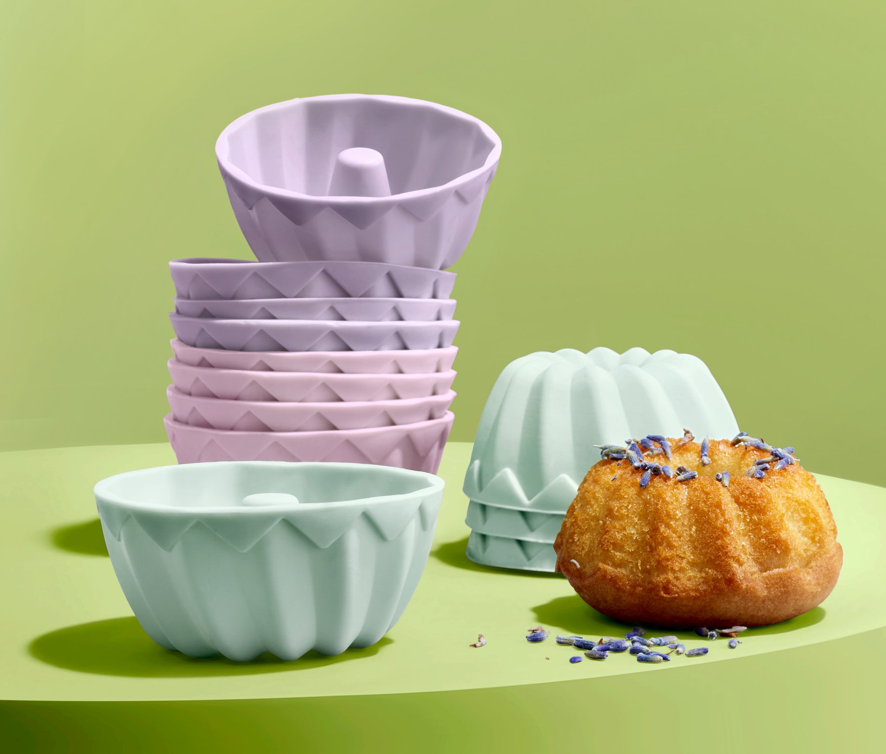 Yeşil bir arka planda Mini Kek Kalıbı Seti bulunur, bir kek lavanta ile süslenmiştir.