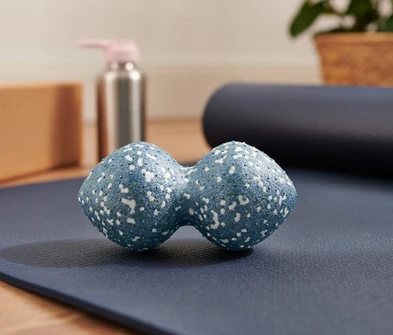 Mavi renkli ikili masaj topu, mavi yoga matının üzerinde duruyor.