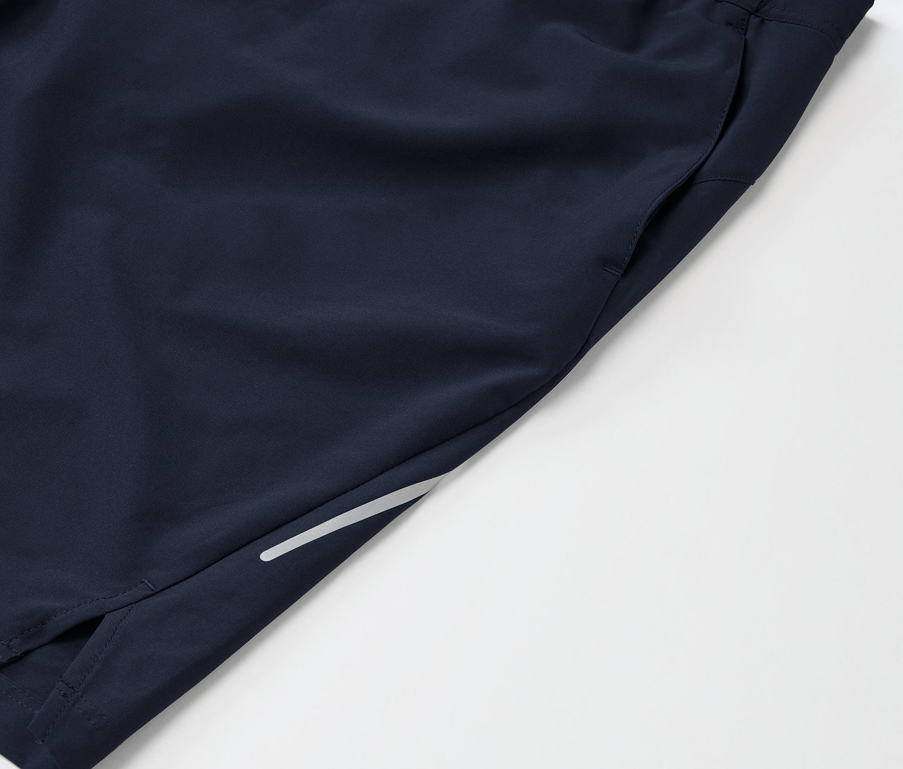 Bacak kısmında cebi ve yansıtıcı detayı olan lacivert spor şortun detayı.