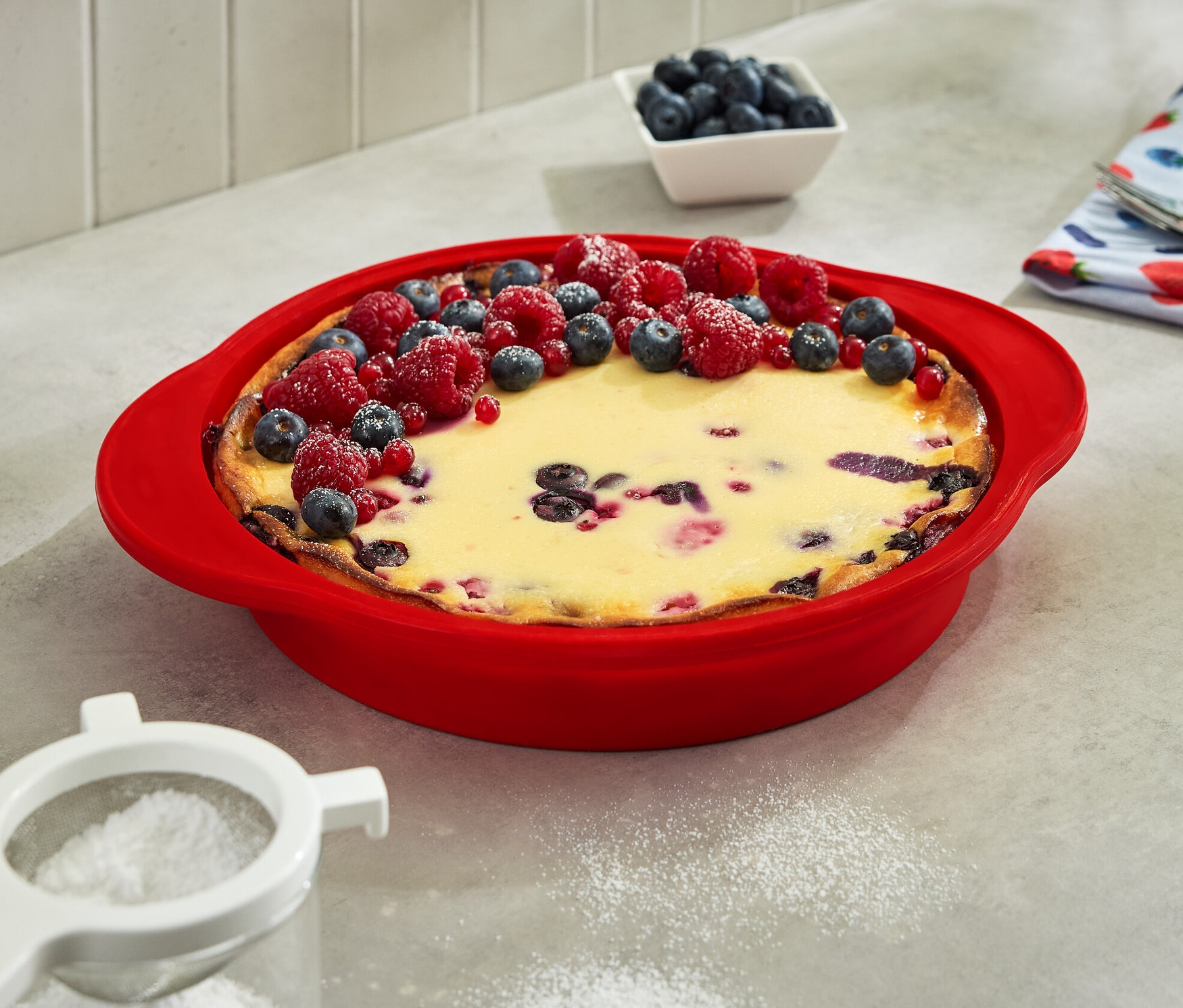 Katlanabilir kek kalıbında yaban mersini ve ahududu ile süslenmiş kek.