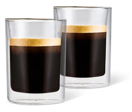 Beyaz bir arka plan üzerinde köpüklü kahve ile doldurulmuş iki adet Caffè Crema Bardağı.