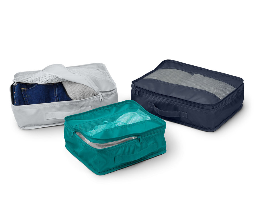 Gri, turkuaz ve lacivert renklerde üç adet seyahat düzenleme çantası.