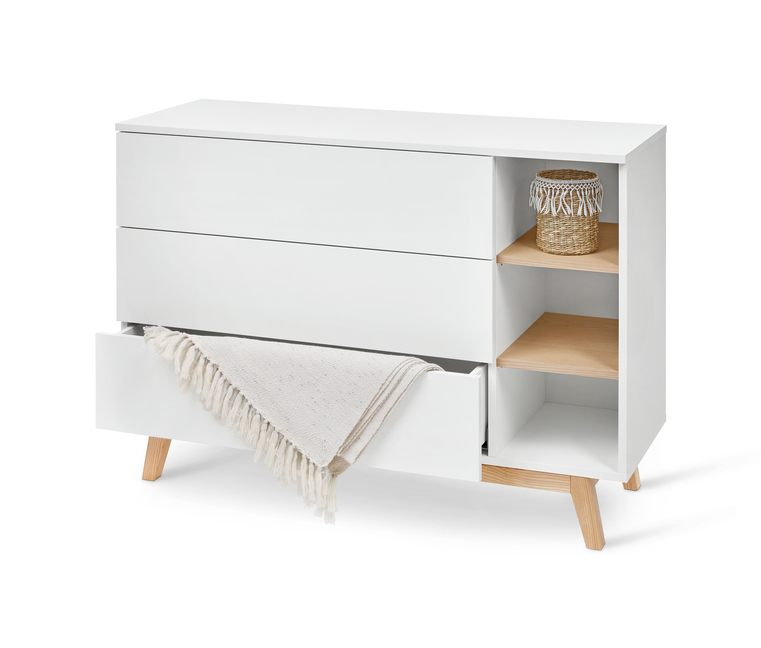 Çekmeceli ve bölmeli beyaz komodin. Bir çekmece açık ve içinde bir battaniye var.