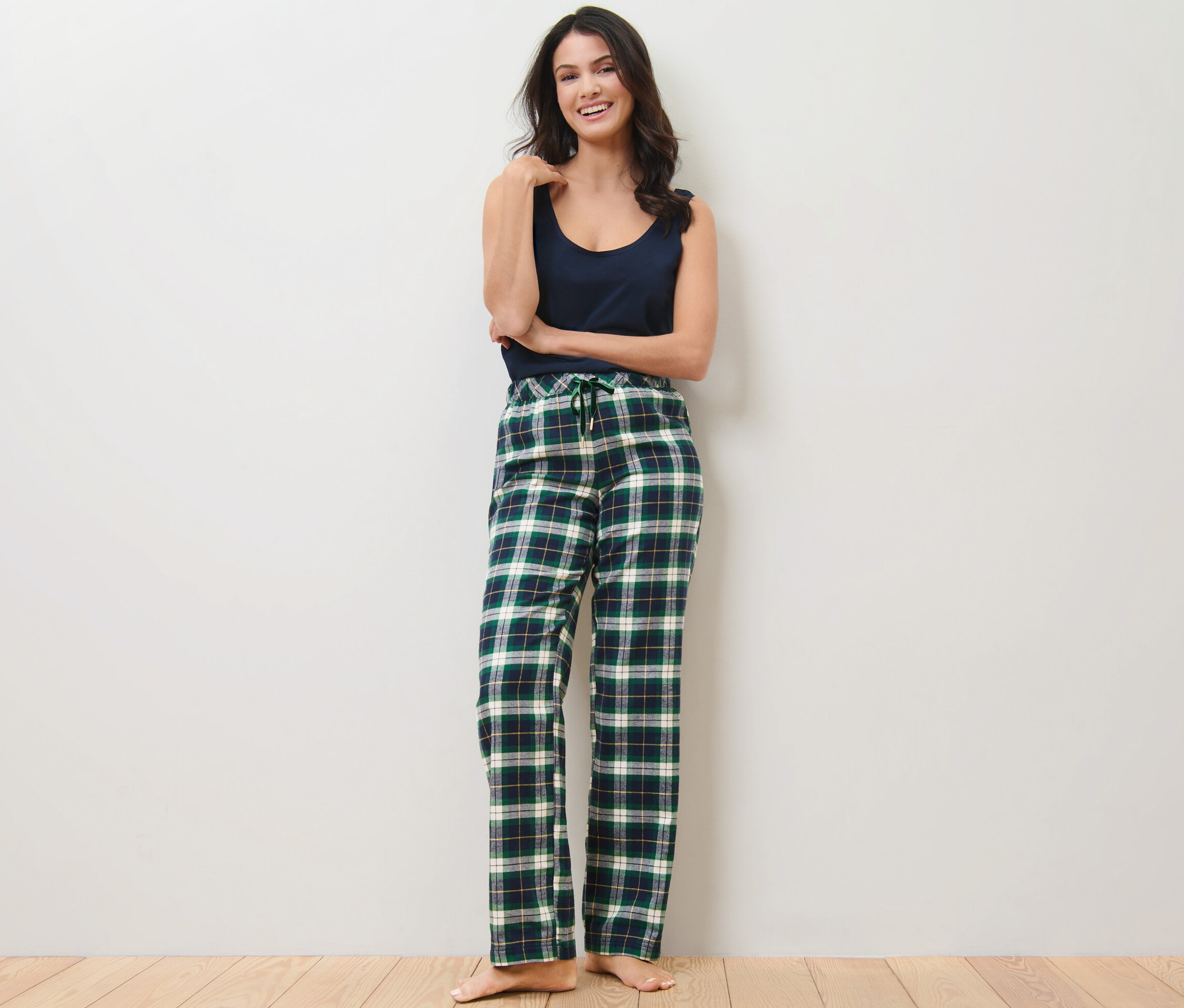 Kadın yeşil rahat flanel pantolonla poz veriyor.