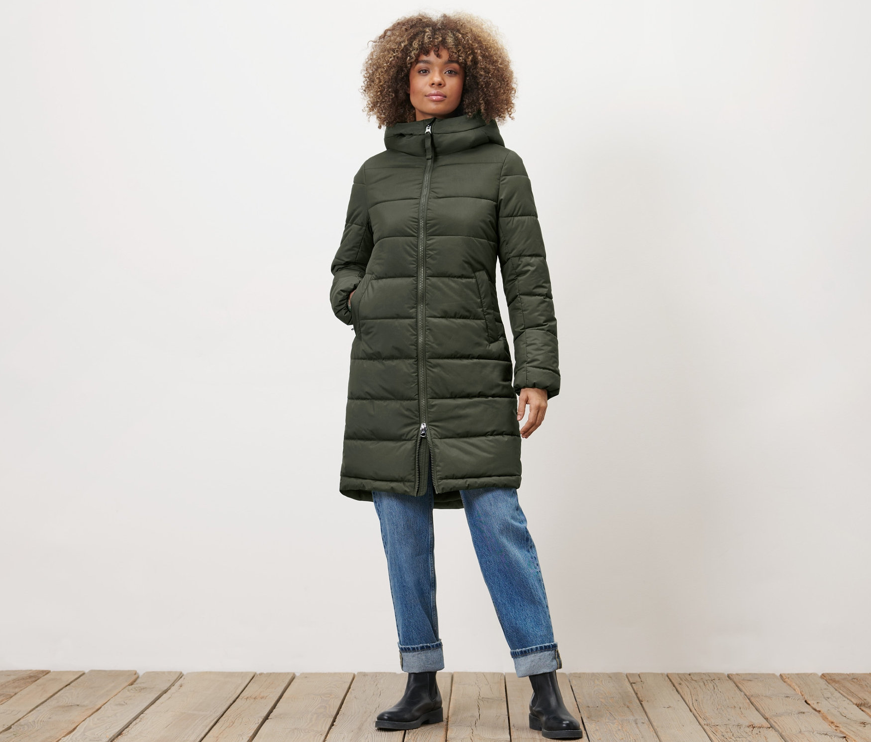 Kadın haki kapitone manto ile poz veriyor