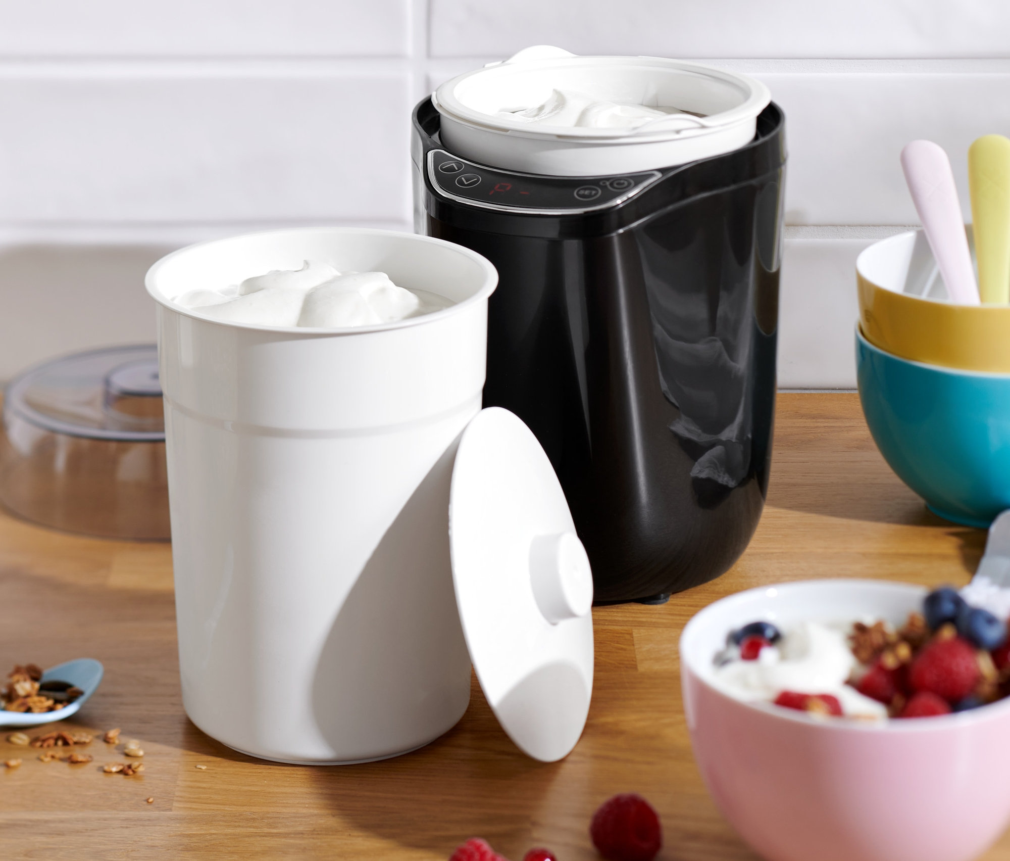 Yoğurt ve granola, masanın üzerinde Yoğurt ve Krem Peynir Yapma Makinesi ile birlikte duruyor.