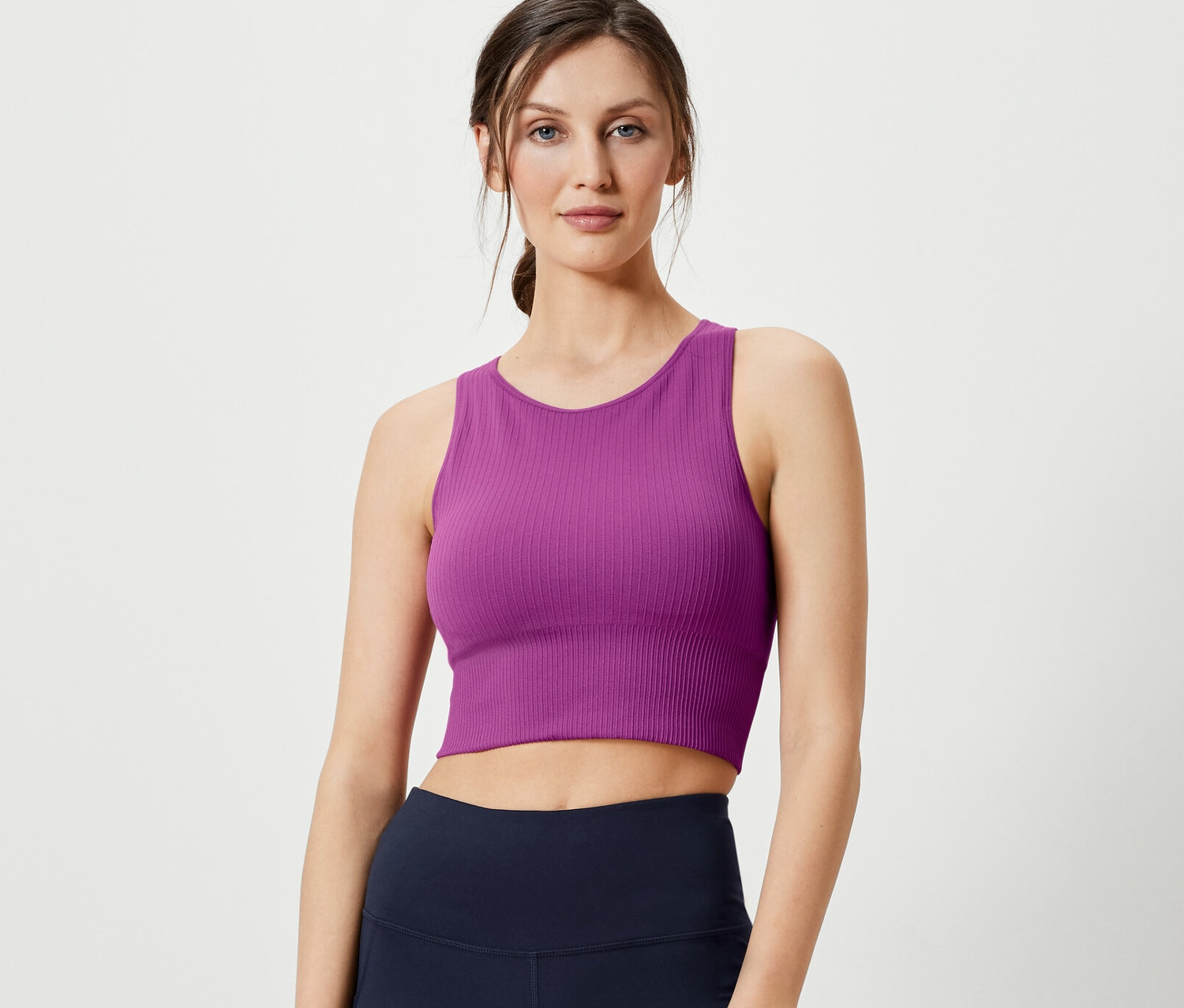 Kadın Dikişsiz Spor Bralet ve lacivert taytla poz veriyor.