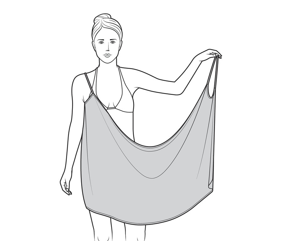 Kadın bir havlu elbise tutuyor.