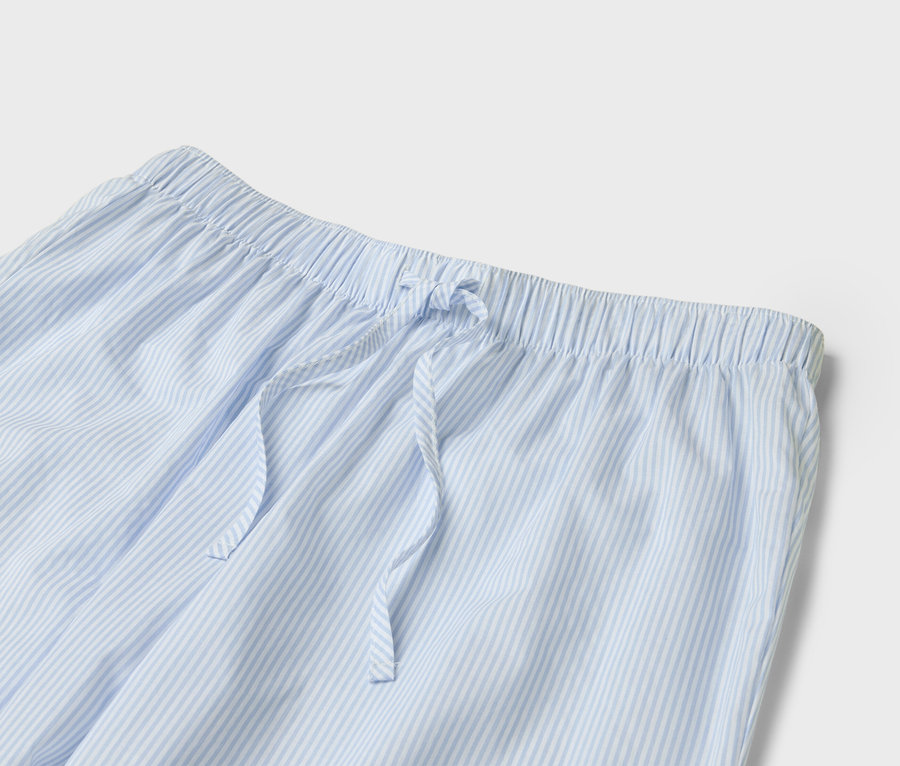İpli, açık mavi-beyaz çizgili bir pijama altının detay görünümü.