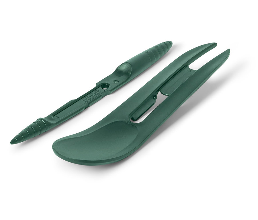 Yeşil bir çim onarım aleti ve golf topu çizgi işaretleyici beyaz bir arka plan üzerinde duruyor.