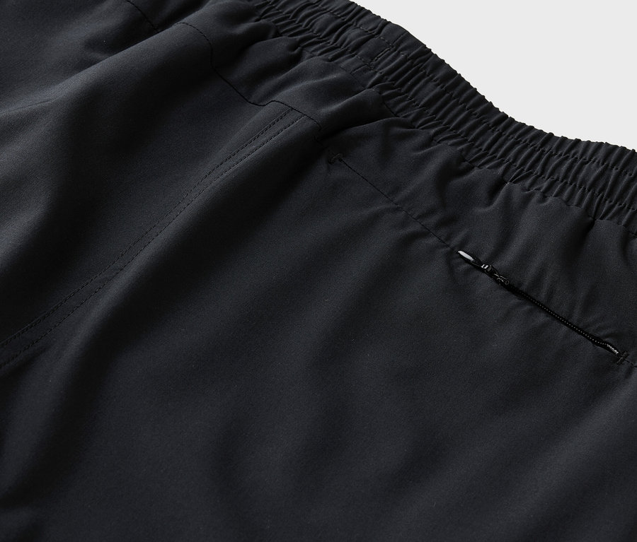 Elastik belli ve fermuarlı cepli siyah bir pantolonun arka kısmının detaylı görüntüsü.