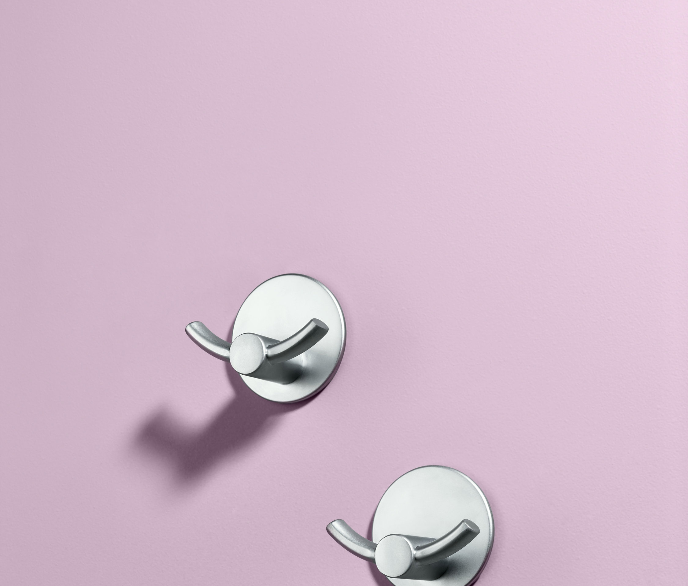 Mor bir duvarda iki adet kendinden yapışkanlı ikili kanca.